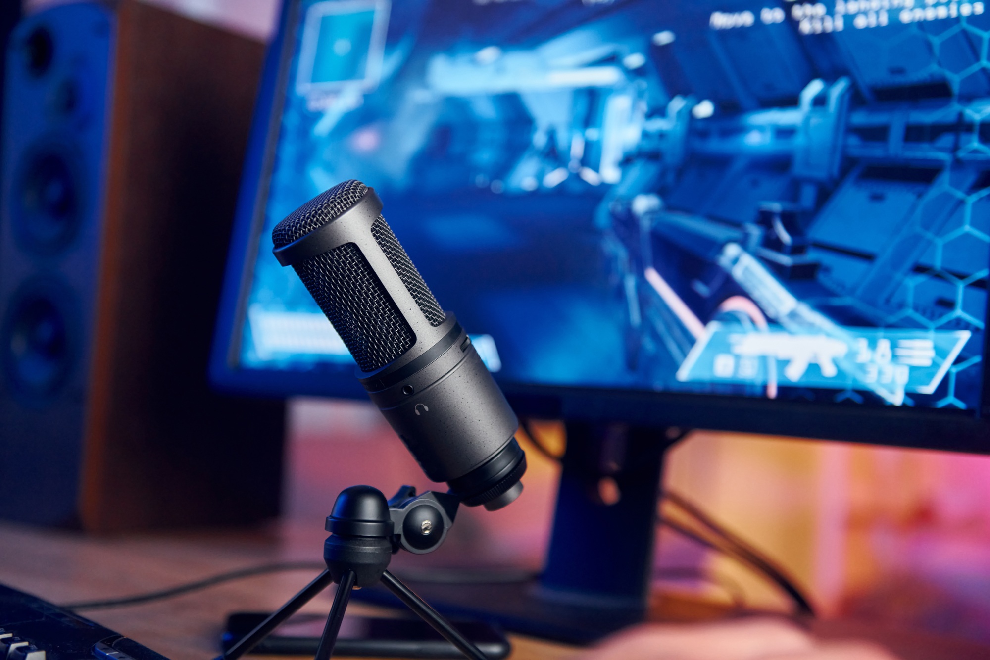 Close up view of microphone. PC at home with shooter game launched on. FPS experience